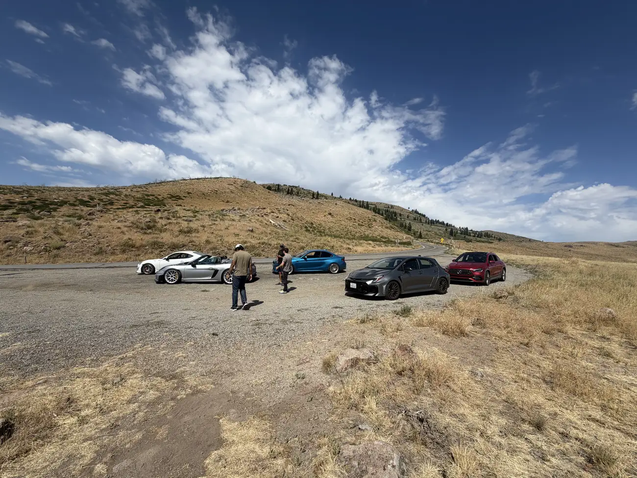 Autoriese cars parked at a high-desert summit pull-off in the Northern Sierra